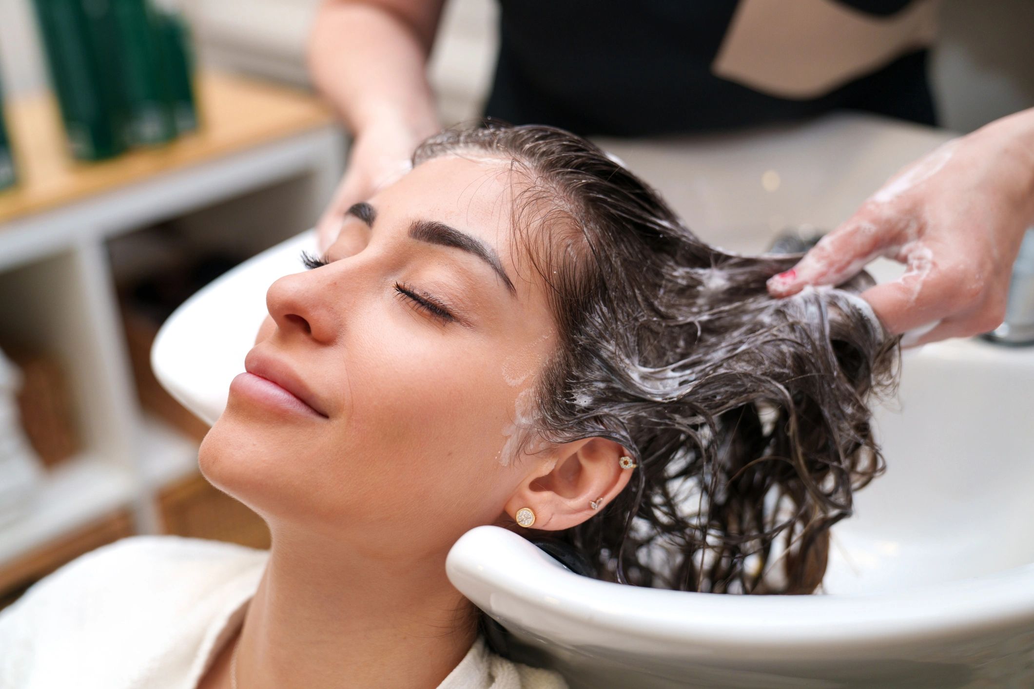 Client enjoying a relaxing shampoo at the salon sink.
